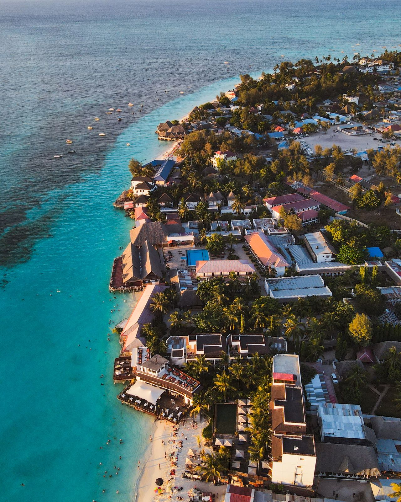Nungwi beach aerial view — turquoise water, white sand, luxury resorts, palm trees