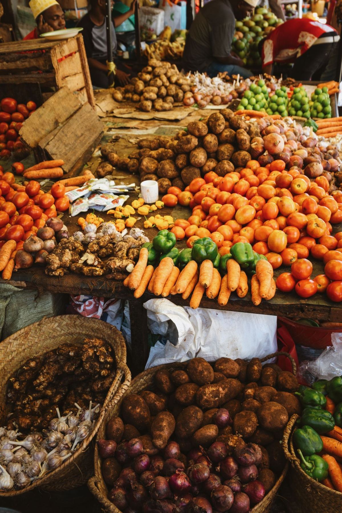 Darajani Market produce — piles of tomatoes, carrots, potatoes, and ginger in Stone Town