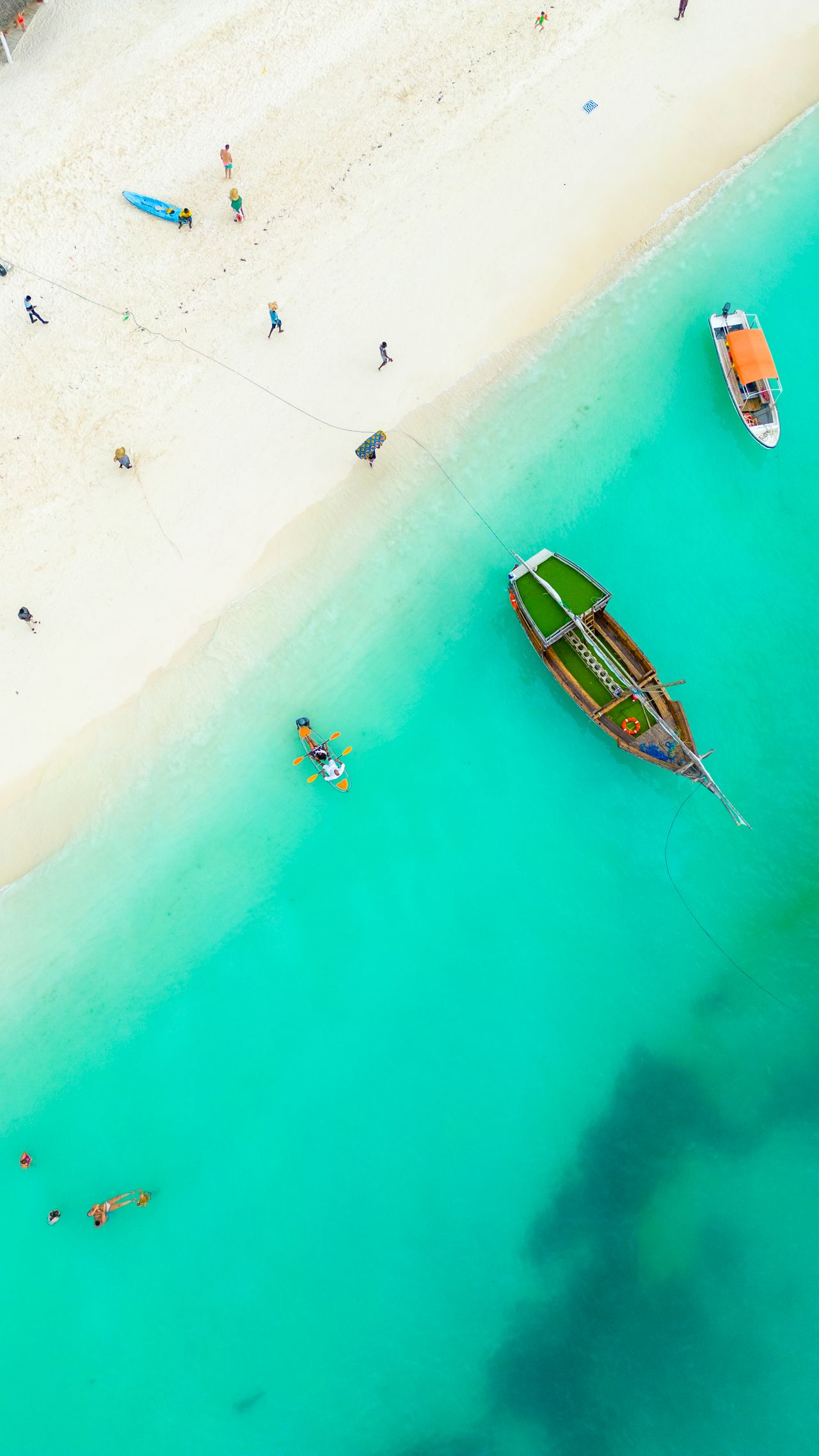 Kendwa beach aerial view — turquoise water, traditional dhow, clear kayak, white sand